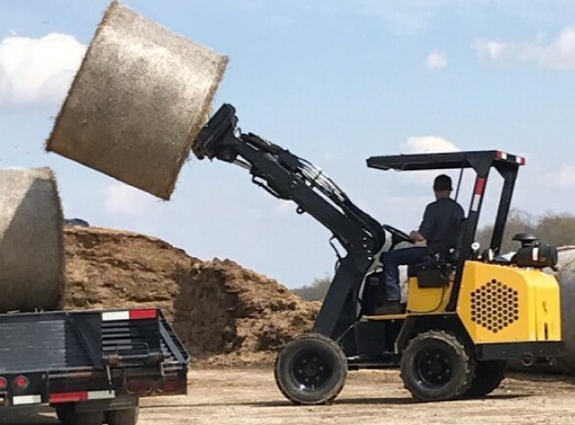 774R Compact Loader stacking bales