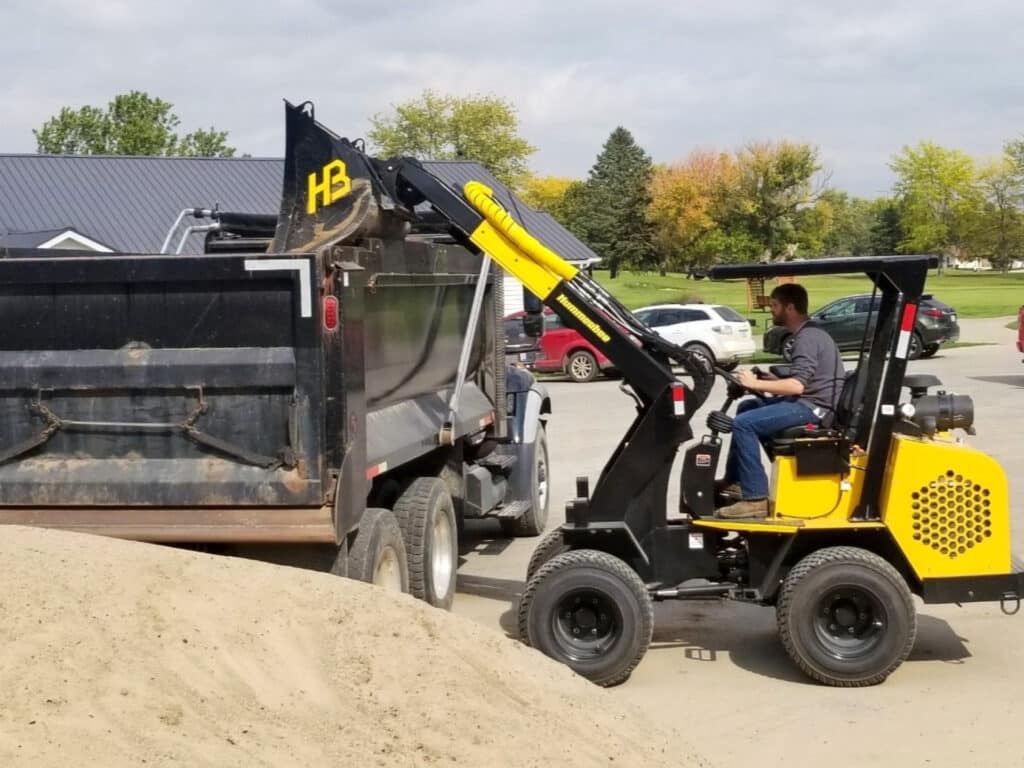 Hummerbee Compact Loader dumping on truck