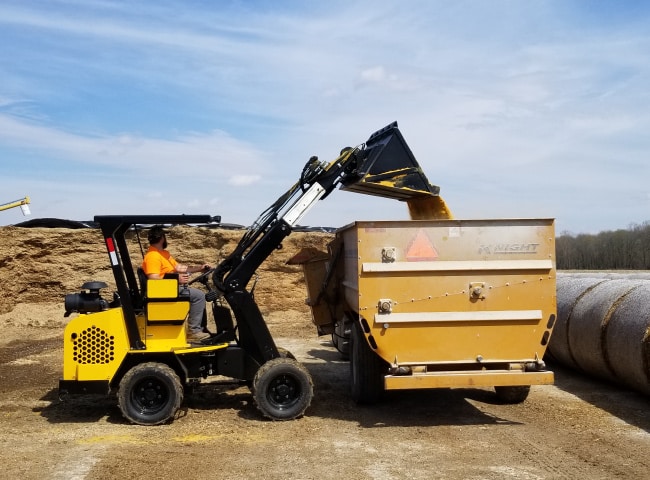Compact Loader dumping corn