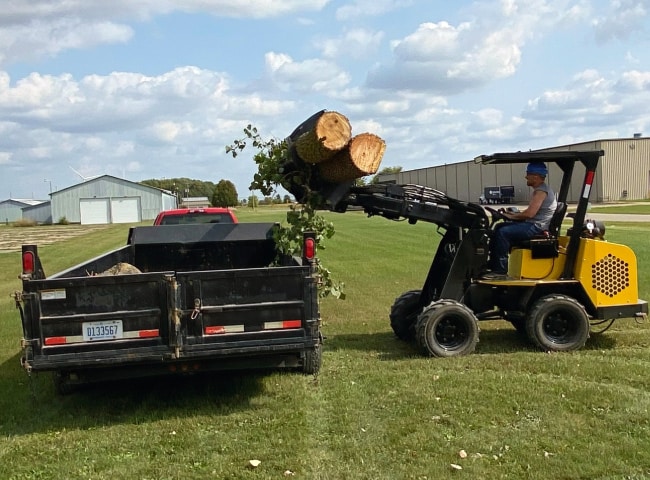 Compact Loader loading logs with grapple