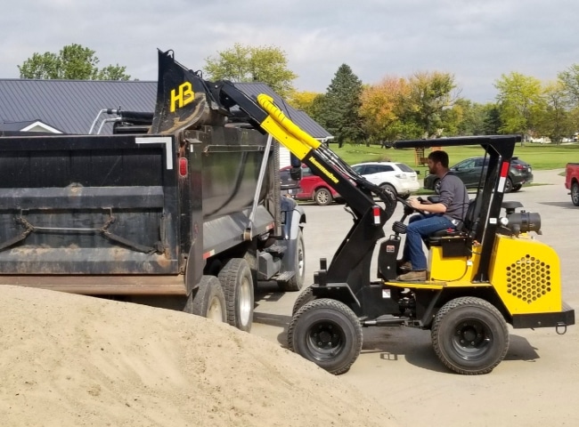 Hummerbee Compact Loader dumping on truck